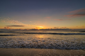 sunset with waves in front of the beach 