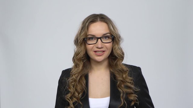 Businesswoman is reporting and tells a lot of interesting informations against grey background