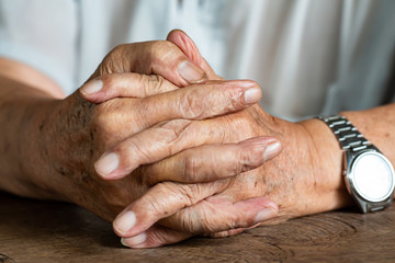 Senior man's holding his hands and praying, Close up & Macro shot, Selective focus, Asian Body skin part, Body language feeling, Religious concept