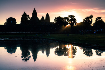 Naklejka premium Angkor Wat Temple in Cambodia with sunset (Dawn) skies with the reflection of a religious monument of architecture.