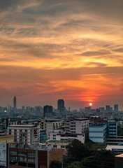 Bangkok city with a beautiful sunset over the skyline with orange skies, buildings and clouds.