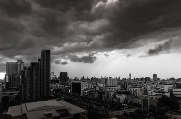 Bangkok city with dramatic cloud storm overpopulated buildings with sunlight beaming through clouds.
