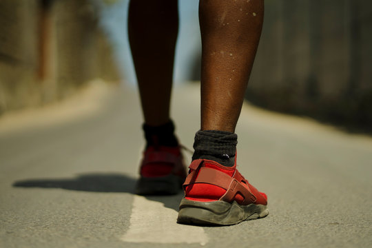 Urban Runner Workout . Back View In Detail Of Athletic Black African American Sport Man Legs And Feet In Running Shoes Training Outdoors On Asphalt Road During Jogging Workout