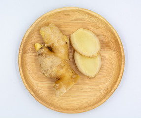 Fresh ginger in wooden bowl on white background