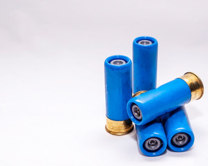 Four blue, rifled 12 gauge shotgun shells on a white background