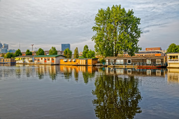 Fototapeta premium Amsterdam floating houses in river Amstel channel