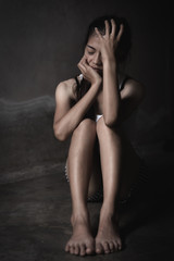 Depression or domestic violence Concept, Black and white image of a young woman crying and covering her face useful to illustrate stress.