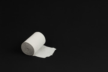rough recycled white toilet paper on black background, close-up, copy space, concept of stomach problems or diarrhea