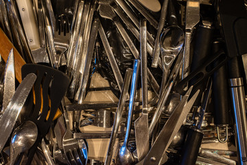 messy kitchen utensils in the drawer