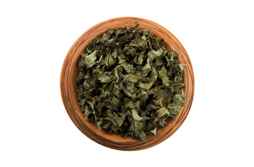 Dry green herbs in a glossy cup isolated on a white background. View from above. Seasoning on isolate. Dry spices.