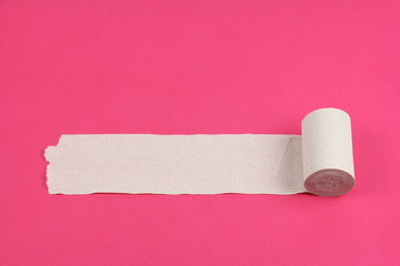 unrolled roll of rough white toilet paper on pink background, close-up, copy space, concept of stomach problems