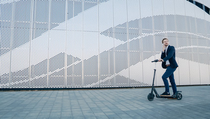 Young Businessman riding scooter and answering phone call. Transportation environmental concept. © mrkotov