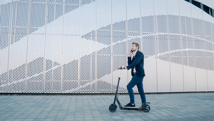 Young Businessman riding scooter and answering phone call. Transportation environmental concept.