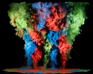 Colorful rainbow paint drops from above mixing in water. Ink swirling underwater