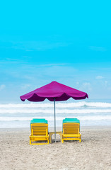 Purple Beach Umbrella With Yellow Lazy Wooden Chair on The Bali Beach During Summer Vacation