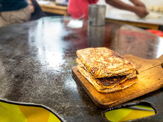 Martabak Telor or Stuffed Omelette Pancake Fried Bread. A Traditional Minang or Padang Cuisine on Flat Frying Pan