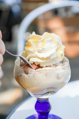 Eisbecher mit Schokolade, Nuss, Sahne und Eierlikör draußen bei Eisdiele