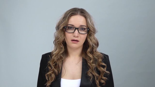 Woman in business suit is upset and tired, takes off her glasses, slow motion