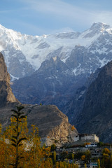 Nature landscape vertical view of Baltit fort and snow capped Karakoram mountain range in the background, Hunza valley. Gilgit Baltistan, Pakistan.