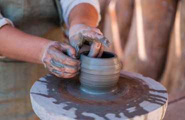Potter is creating earthenware on potter's wheel.