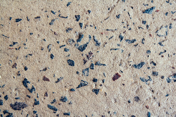 Structure of concrete surface with admixtures of stones as background image. Rough building material of gray color