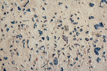 Structure of concrete surface with admixtures of stones as background image. Rough building material of gray color