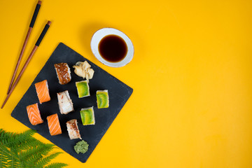 A set of sushi roll different type on a yellow background. Top view with copy space. Traditional Asian food.