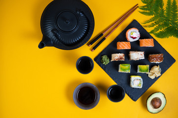 A set of sushi roll different type on a yellow background. Top view with copy space. Traditional Asian food.