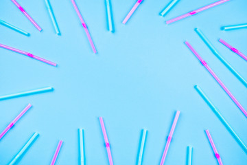 Blue and pink cocktail straws on a color background.