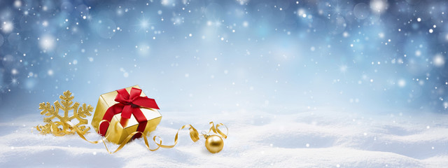 Festive Christmas snow background with copy space. Golden gift box with red ribbon, snowflake and...