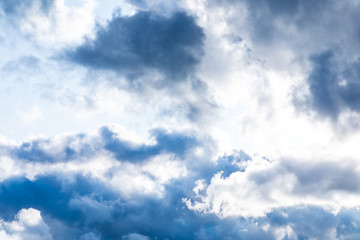 The vivid sky or heaven background with white and blue clouds under the sun rays