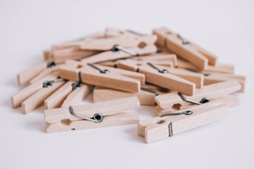 Wooden clothespins scattered on a white background. Copy space