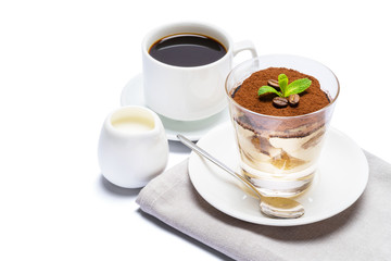 Classic tiramisu dessert in a glass, cup of espresso coffee and cream isolated on white background with clipping path