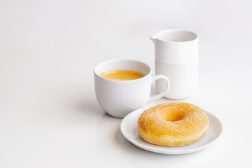 Cup of coffee with classic sugar donut on white background with copy space.Good morning and breakfast concept
