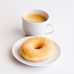 Cup of coffee with classic sugar donut on white background.Copy space