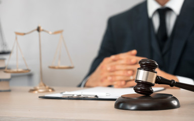 Law and Legal services concept. Male lawyer or judge working with contract papers, Law books and wooden gavel on table in courtroom 
