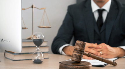 Law and Legal services concept. Male lawyer or judge working with contract papers, Law books and wooden gavel on table in courtroom 