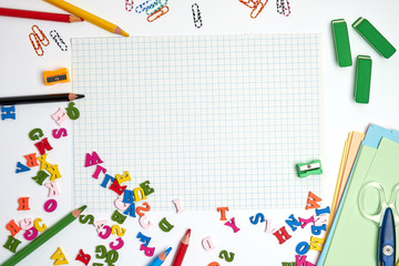 school supplies: multicolored wooden pencils,  notebook, colored paper and  blank white sheet