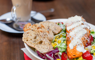 Dinner at restaurant. Close-up salad with grilled chicken, corn, tomato and cucumber