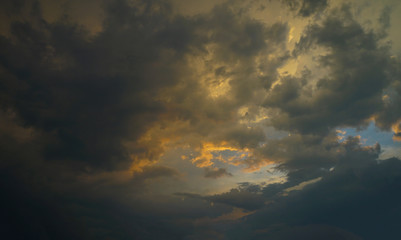 Summer evening sky, golden color on the clouds, a beautiful combination of warm and cold colors. 