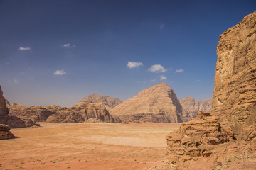 Fototapeta na wymiar Wadi Rum Jordan desert scenic landscape view with valley surrounded by sand stone rocky mountains 