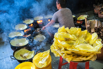 Banh xeo, Vietnamese traditional street food yellow crispy rice flour cake. Sizzling cake, named...