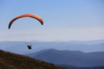 flying paraglider in mountains