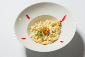 Fusilli pasta with cheese served in white plate