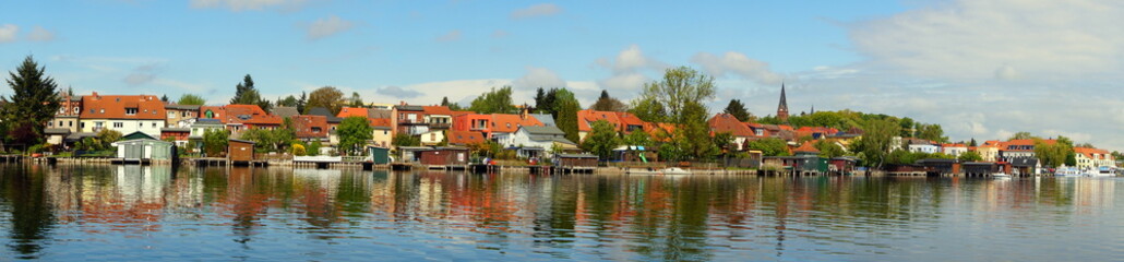 Fototapeta na wymiar weites Panorama vom See zur Stadt Malchow, die sich im Wasser spiegelt
