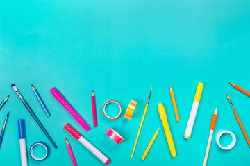 School items as a frame on blue background. Trendy colors, flat lay style. Back to school concept.