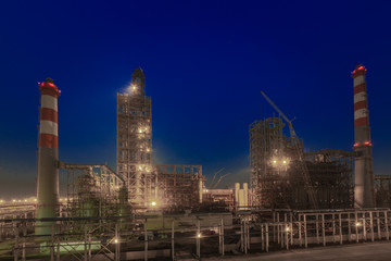 the form of metal pipes of a refinery in the open air at night
