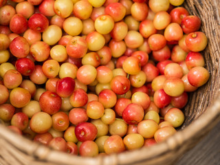wicker basket with ripe yellow cherries top view