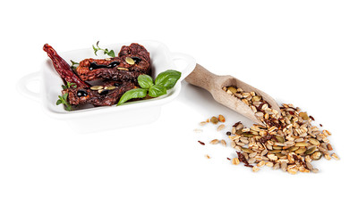 Decoration with dried tomatoes and muesli on a white background.