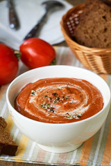 Soup puree with baked tomatoes in a white bowl 